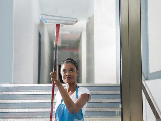 A woman holding a mop in her hand.